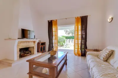 a living room with a couch and a fireplace at Small Villa 4Pax -Shared Pool @ Homesbyfc in Albufeira