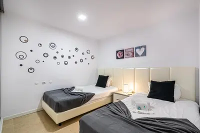 two beds in a room with clocks on the wall at BeGuest Aveiros Beach View Apartment in Albufeira