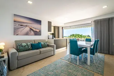 a living room with a couch and a table and chairs at BeGuest Aveiros Beach View Apartment in Albufeira
