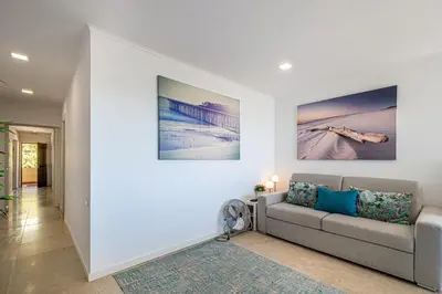 a living room with a couch and a painting on the wall at BeGuest Aveiros Beach View Apartment in Albufeira