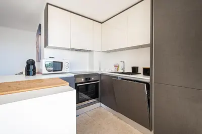 a small kitchen with white cabinets and appliances at BeGuest Aveiros Beach View Apartment in Albufeira