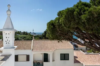 a white church with a tower and a tree at Villa Isabel in Vale do Lobo