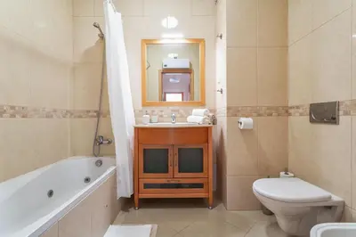 a bathroom with a sink and a toilet and a tub at BnB Homes Ocean View Apartment with relax Terrace, 2 Swimming pools & Tennis court in Albufeira