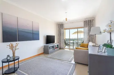 a view of a beach with a town in the background at BnB Homes Ocean View Apartment with relax Terrace, 2 Swimming pools & Tennis court in Albufeira