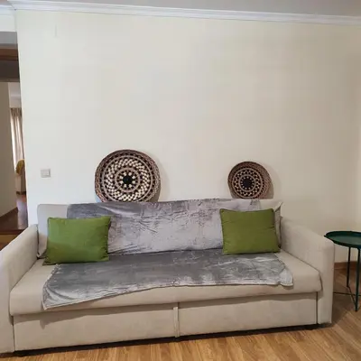 a couch with two green pillows in a living room at Casa Alfarroba in Albufeira