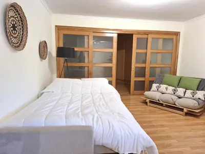 a bedroom with a large white bed and a couch at Casa Alfarroba in Albufeira