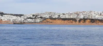 a view of a beach with white buildings in the background at Casa Alfarroba in Albufeira