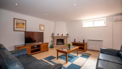a living room with a couch and a tv and a fireplace at Amora Classic Villa in Vilamoura