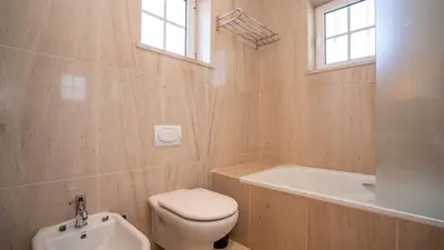 a bathroom with a toilet and a tub and a sink at Amora Classic Villa in Vilamoura