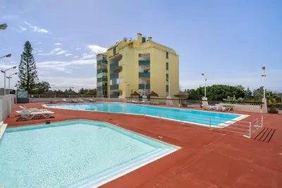 a large swimming pool with a building in the background at Amendoeiras Family Apartment in Quarteira