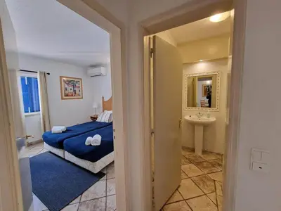 a bedroom with a blue bed and a sink at douceur d'algarve in Albufeira