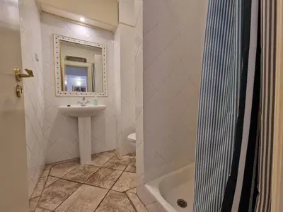 a white bathroom with a sink and a mirror at douceur d'algarve in Albufeira