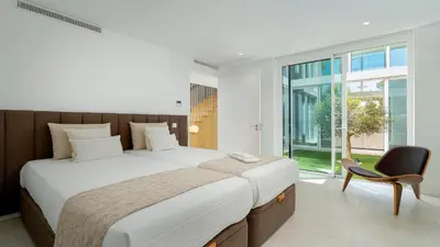 a bedroom with a large bed and a chair at Villa Serenity- CleverDetails, Central Vilamoura, Sleeps 4 adults and 2 children, located in the center in Vilamoura