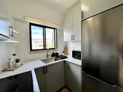 a kitchen with a stainless steel refrigerator and a window at Albufeira Design by Homing in Albufeira