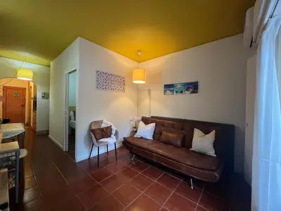 a living room with a brown couch and a chair at Casa Girassol Old Town in Albufeira