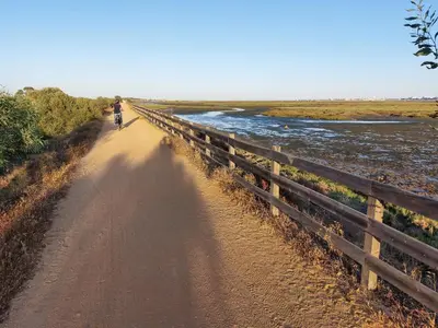 a person riding a bike down a dirt road at Ancão Beach Apartment in Almancil
