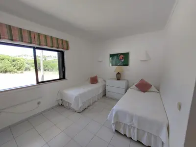 a white room with two beds and a window at Ancão Beach Apartment in Almancil