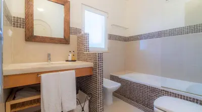 a bathroom with a sink and a tub and a toilet at Villa Prado - Beautiful beachfront villa in Albufeira