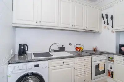 a white kitchen with a sink and a dishwasher at Magnífico apartamento perto da praia in Albufeira