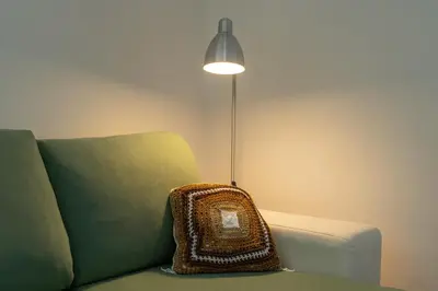 a pillow sitting on a couch next to a lamp at Magnífico apartamento perto da praia in Albufeira
