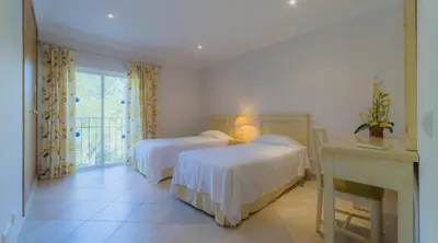 a bedroom with two beds and a desk and a window at Villa Tulipa - luxury golfing resorts in Almancil