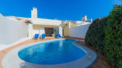 a swimming pool in front of a house at Villa Tulipa - luxury golfing resorts in Almancil