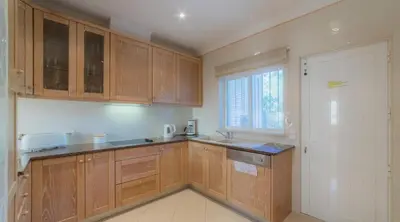 a kitchen with wooden cabinets and a window at Villa Tulipa - luxury golfing resorts in Almancil