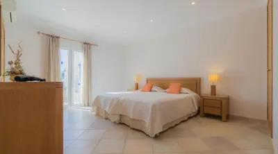 a bedroom with a bed with orange pillows on it at Villa Tulipa - luxury golfing resorts in Almancil