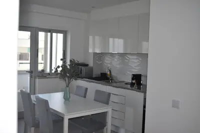 a white kitchen with a white table and chairs at GrowIN Stay Downtown in Faro