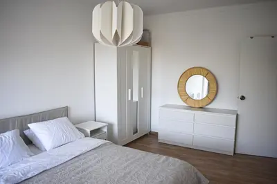 a white bedroom with a bed and a mirror at GrowIN Stay Downtown in Faro