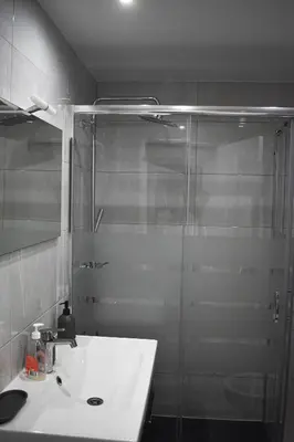 a bathroom with a sink and a glass shower at GrowIN Stay Downtown in Faro