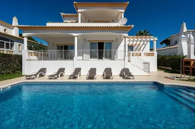 a villa with a swimming pool in front of a house at Villa White Cottage by SAPvillas in Vilamoura