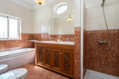 a bathroom with a sink and a toilet and a mirror at Villa White Cottage by SAPvillas in Vilamoura
