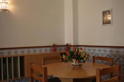 a dining room table with a vase of flowers on it at Albufeira Beach - Tranquilidade junto à praia e ao centro! in Albufeira