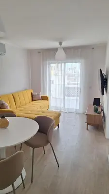a living room with a yellow couch and a table at Casa Rafinha in Faro