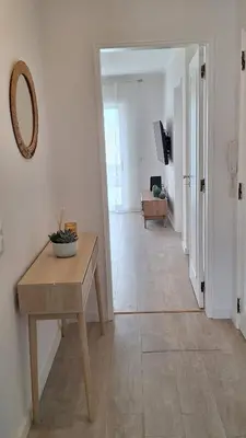 a hallway with a table and a mirror on the wall at Casa Rafinha in Faro