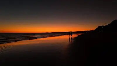 a person walking on the beach at sunset at PARADISE ON THE BEACH in Albufeira