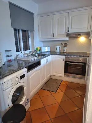 a kitchen with white cabinets and a washing machine at Piece of Paradise @ Balaia Golf Village, Albufeira, PORTUGAL - 4 STAR in Albufeira