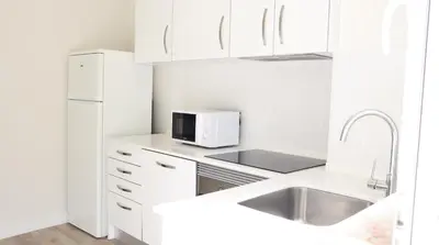 a white kitchen with a sink and a microwave at MFA By Albufeira Rental in Albufeira