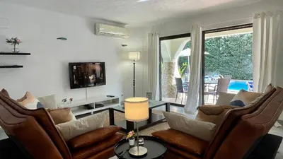 a living room with a couch and chairs and a tv at Golfinho by Check-in Portugal in Albufeira