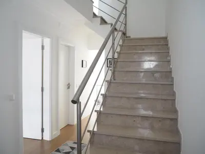 a staircase in a home with white walls and wooden floors at Charming V2 next to ocean, golf & natural reserve in Albufeira