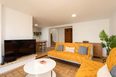 a living room with a couch and a tv at The Albufeira Concierge - Villa Pool & Tennis in Albufeira