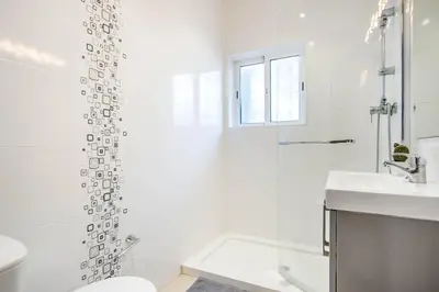 a white bathroom with a toilet and a sink at Villa Patio in Albufeira