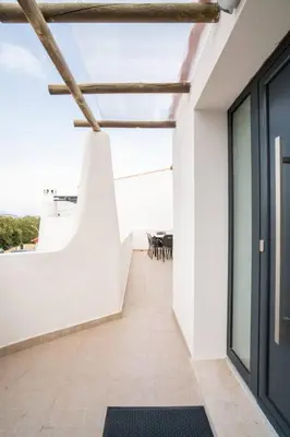 a hallway of a white building with a black door at Casa Azinheira 1ºa- Albufeira in Albufeira