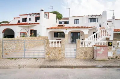 a white house with a stone fence at Casa Azinheira 1ºa- Albufeira in Albufeira