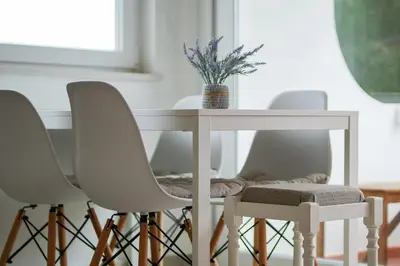 a white table with three chairs and a table with a plant at Sunny Albufeira - 5min to the beach by LovelyStay in Albufeira