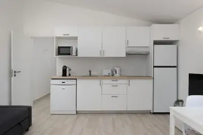 a white kitchen with white cabinets and appliances at Sunny Albufeira - 5min to the beach by LovelyStay in Albufeira