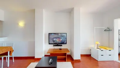 a living room with a tv on a white wall at Apartamento CPiscina-Albufeira in Albufeira