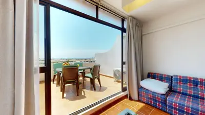 a living room with a couch and a table with chairs at Apartamento CPiscina-Albufeira in Albufeira