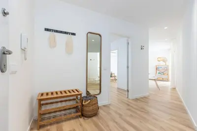 a hallway with a mirror and a wicker stool at New 2bedroom Apartment w Terrace & Infinity Pool in Olhos de Água